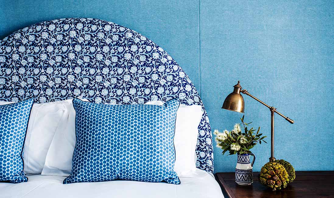 blue-upholstered-wall-print-headboard-pillows-cococozy-halcyonhouse
