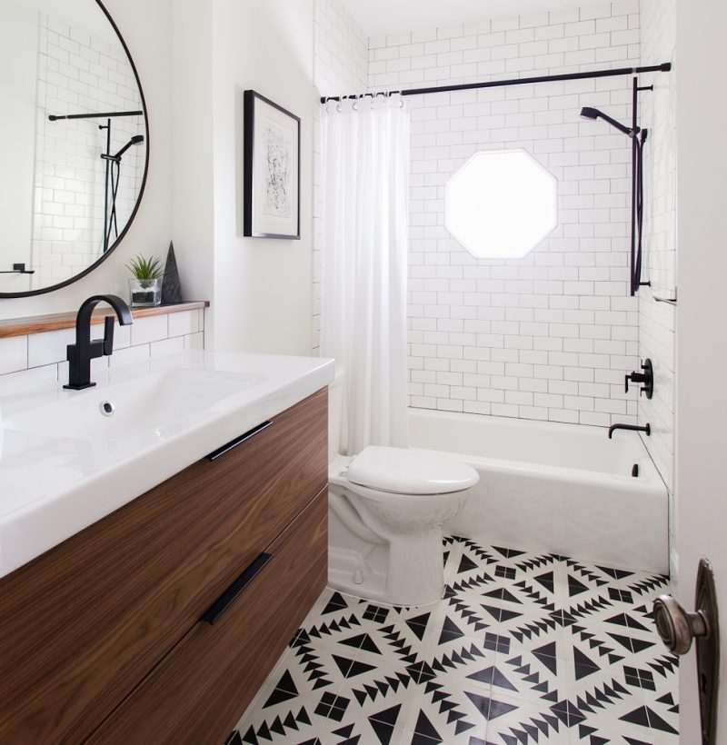 bright white bathroom round mirror dark faucet tiled floor