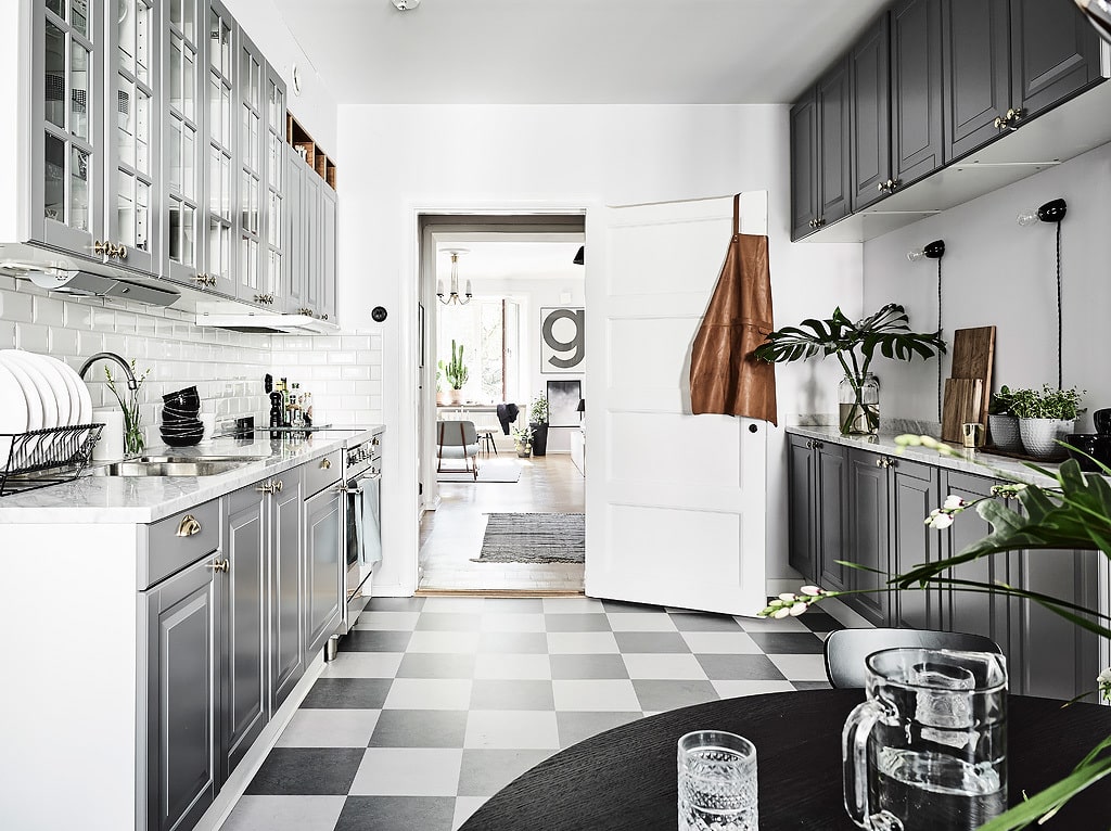 Alt tag for small-eat-in-kitchen-design-checkered-floor-grey-cabinets-exposed-brick-galley-gold-knobs-pulls-cococozy-entrance