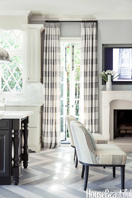 Grey and white kitchen by Mary McDonald with striped drapery and chevron pattern floor