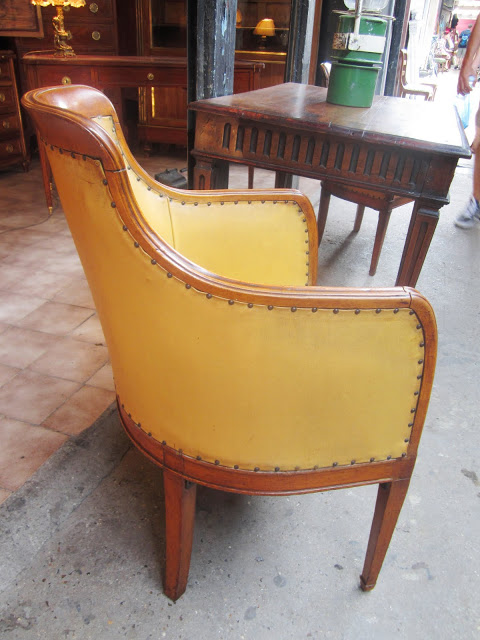 Close up of the back and side of one of the the 17th century antique petite barrel side chairs upholstered in a mustard yellow leather like material