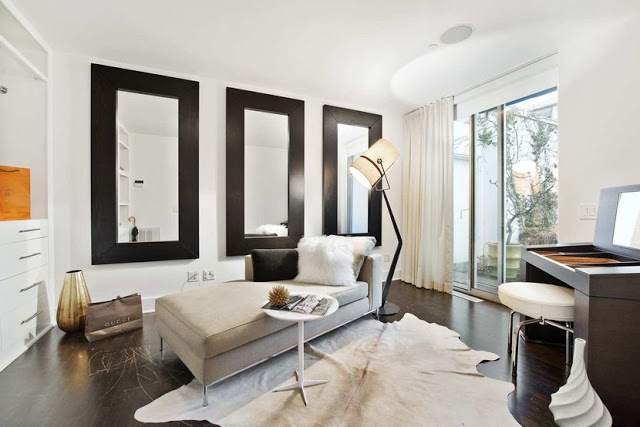 Office in a Soho Condo in New York City with white walls, black mirrors and an animal skin rug