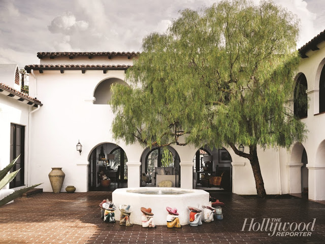 interior courtyard of a Spanish Colonial Revival home with a fountain and willow tree