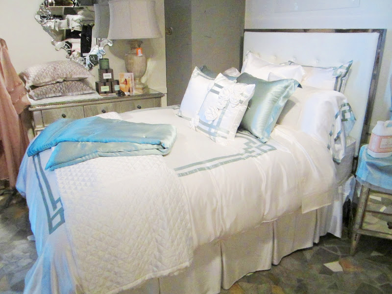 Bed with blue and white silk bedding by Kumi Kookoon