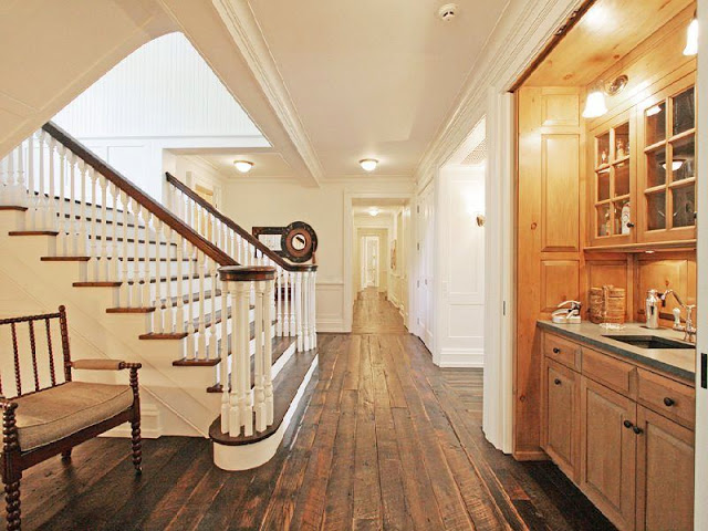 Main hall rustic wood floors, a wood bench and a staircase