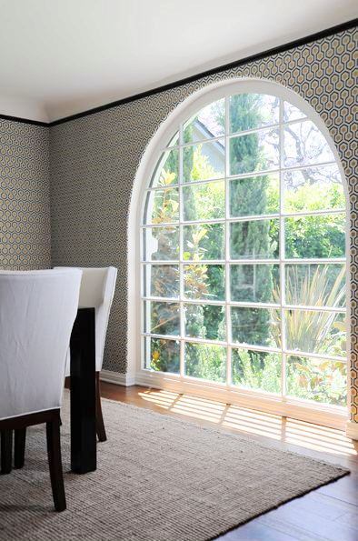 Close up of the arched window, graphic wallpaper and sleek black crown molding