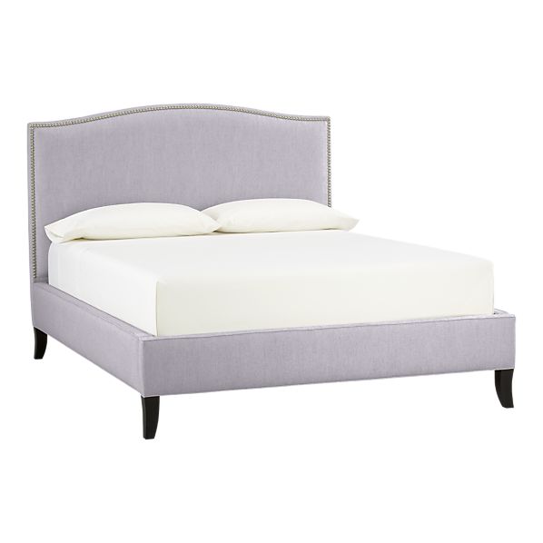 Queen bed with light purple linen upholstery and nailhead trim