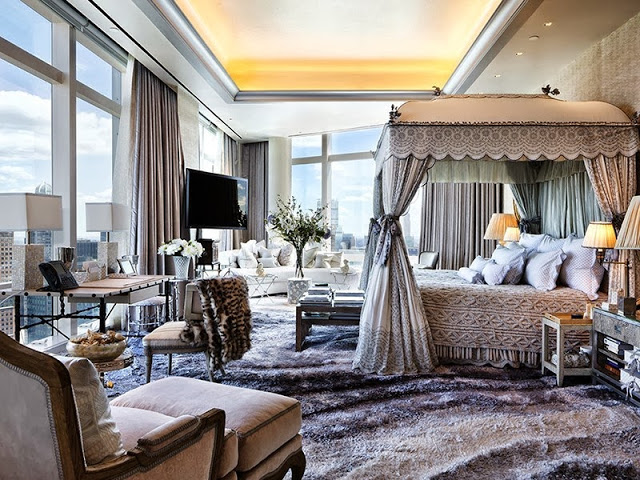 Master bedroom with wrap around floor to ceiling windows, plush rugs and a large canopy bed