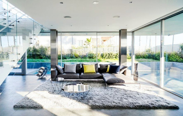 Modern family room with stainless steel columns, grey shag rug, and floor to ceiling windows in the Flip Flop House