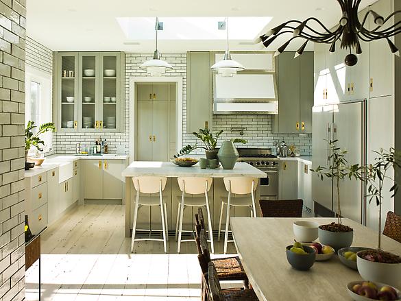 Eat in kitchen with white subway tile walls and backsplashes with dark grout, knotty wood floor, grey cabinets and drawers, an island with a marble counter top and two pendant lights