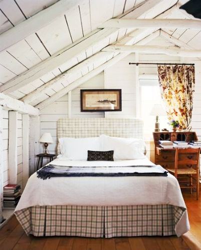 rustic country bedroom a a plaid slip covered headboard, roof line post beam ceiling, rustic wood desk, chair and wood floor