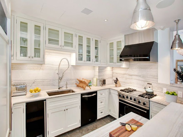kitchen with white cabinets, counter tops, walls and island but black appliances