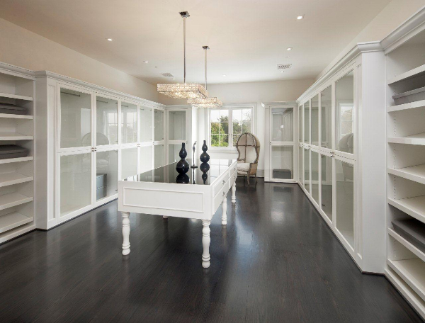 White built in shelves square crystal pendant light white cabinets with glass fronts wood floor walk in closet mansion 