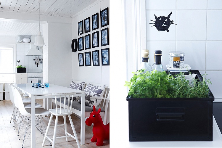 On the left there is a white dining room with a white table, eames chair and bench style seating, on the walls are 12 photographs in black frames arranged in a rectangle, in the corner there is a red donkey. On the right there is a black bin on a white counter in front of a white tile wall with herbs, bottles and other items
