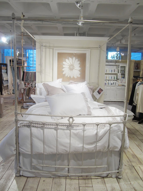 White bedding with cane pattern board by Monde Maison on a bed with a metal bedframe