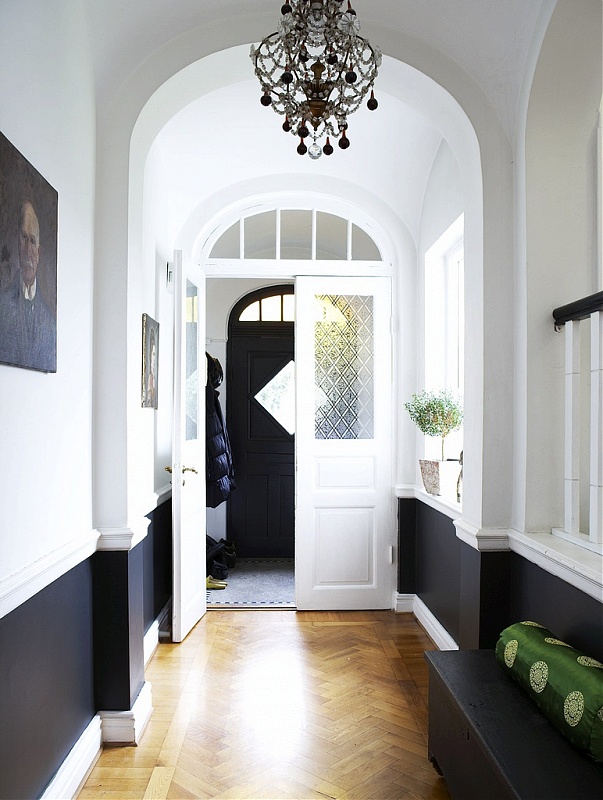 Black and white entry way with herringbone wood floor and a chandelier