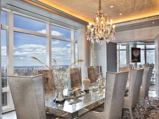 Formal dining room with city view, crystal chandelier, mirrored table and high backed armchairs with nail head trim