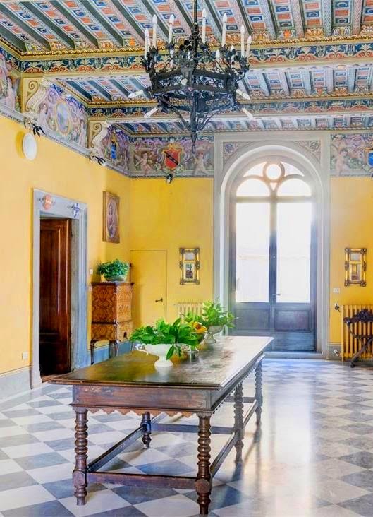 Room in Castello di Modanella with painted ceiling and yellow walls in Tuscany