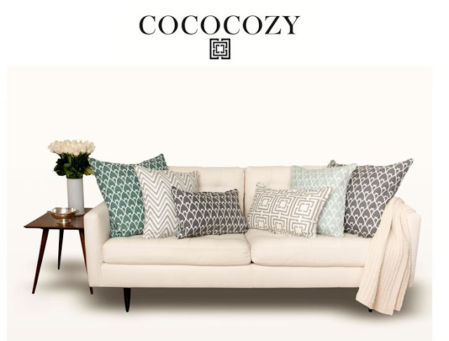 Sofa with gray and sea green pillows and roses