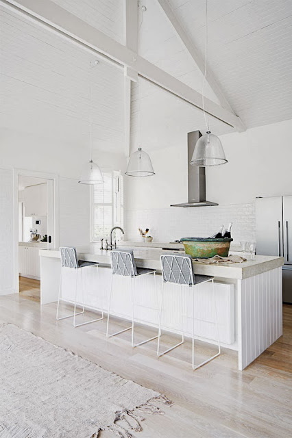 White kitchen with high ceilings and exposed beams