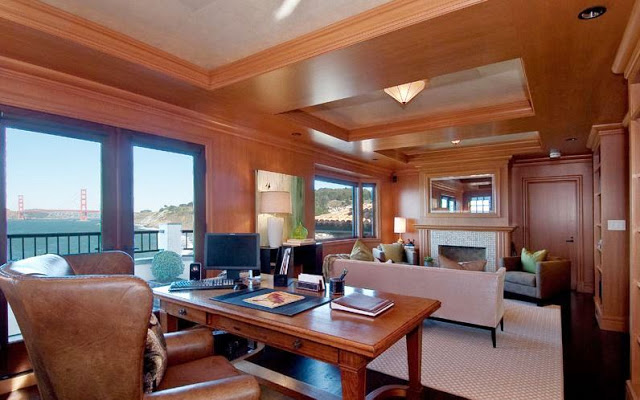 wood paneled home office/library with a tile fireplace, sofa and a view of the Golden Gate Bridge
