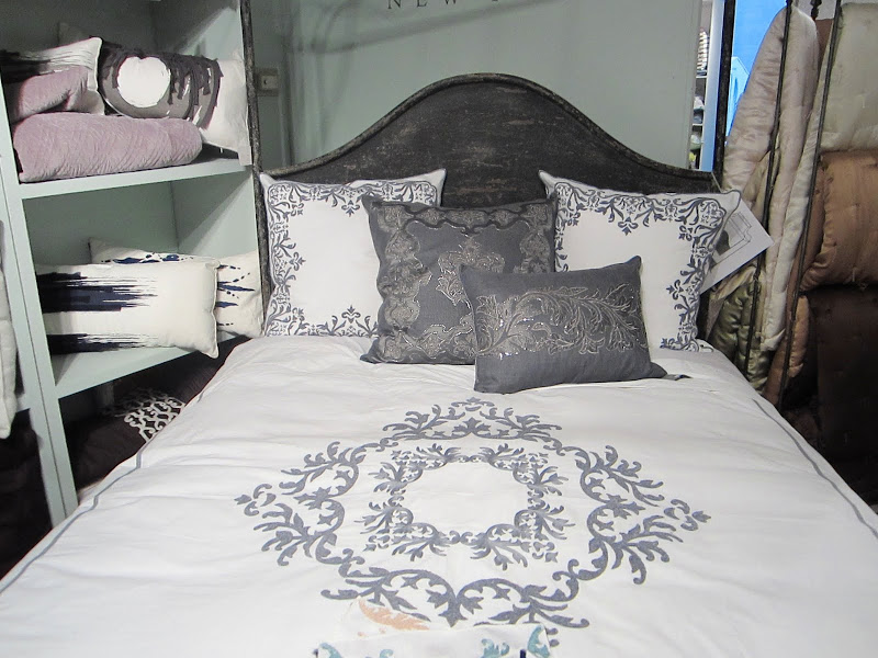 Bed with wood headboard stained dark grey and embroidered bedding with crystal beads from Ankasa