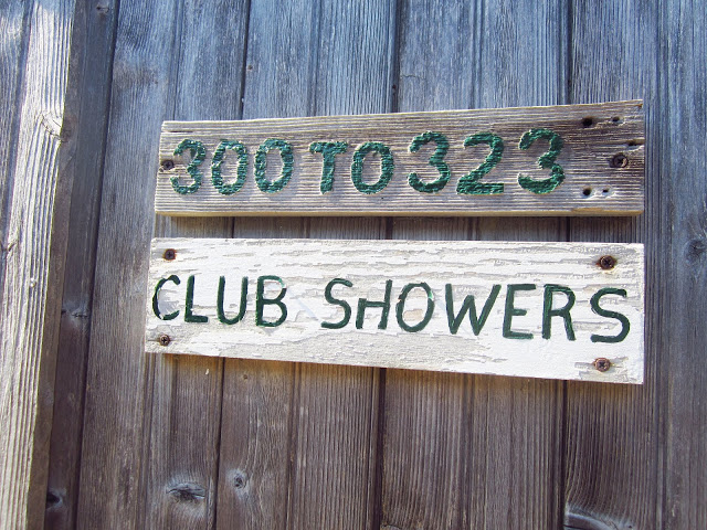 wood sign that says "300 to 323" with a second wood sign below it saying "CLUB SHOWERS"