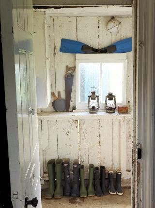 wellies in a rustic mudroom with lanterns