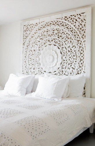  White bed with a beautiful carved panel headboard and eyelet bedspread 
