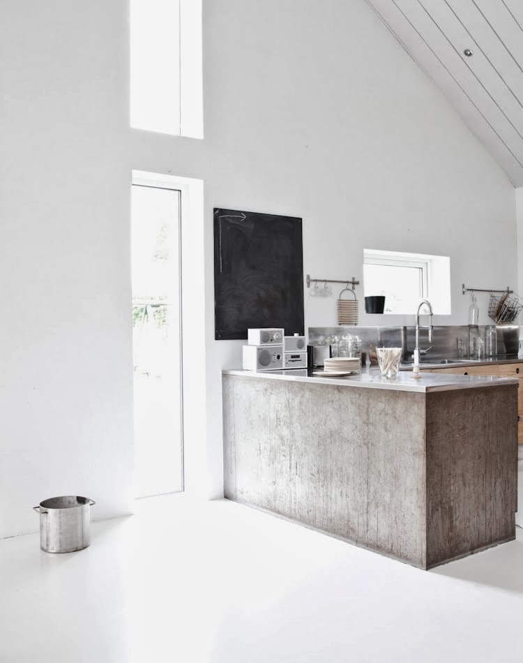 Minimalist kitchen with stainless counter tops and a black board 