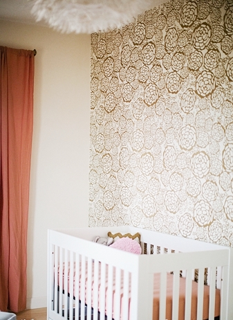 feature wall gold wallpaper white crib baby room nursery peach accents