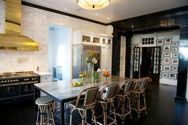 Kitchen with marble subway walls, white cabinets, dark wood floors, vintage light fixture over the island and Drucker's French Bistro barstools, an ILVE Majestic stove with a bass hood and a black molded entry way