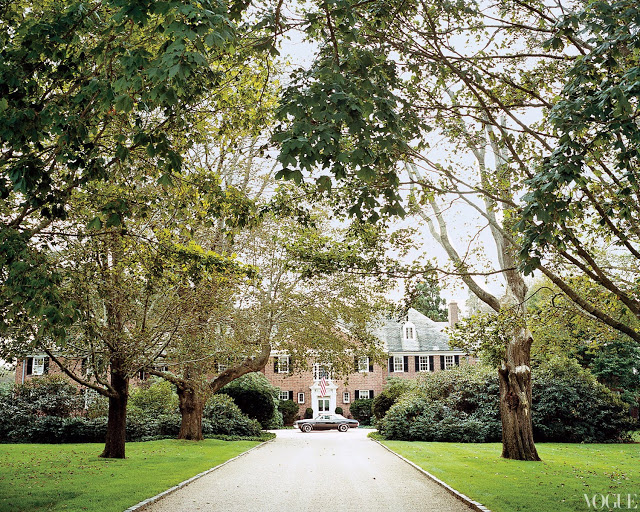 exterior of brick Georgian style house with long driveway surrounded by allee trees