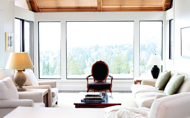 Vancouver apartment with white sofas with a hillside view of green evergreen trees