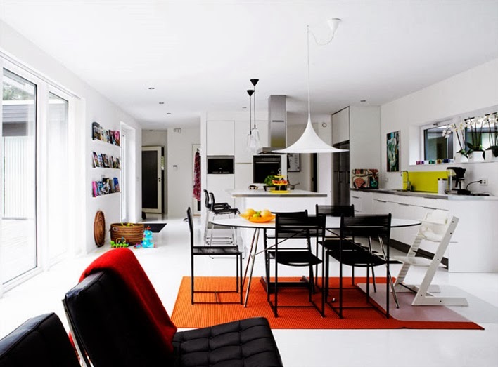 Modern open kitchen, living room and dining room with black Barcelona chairs