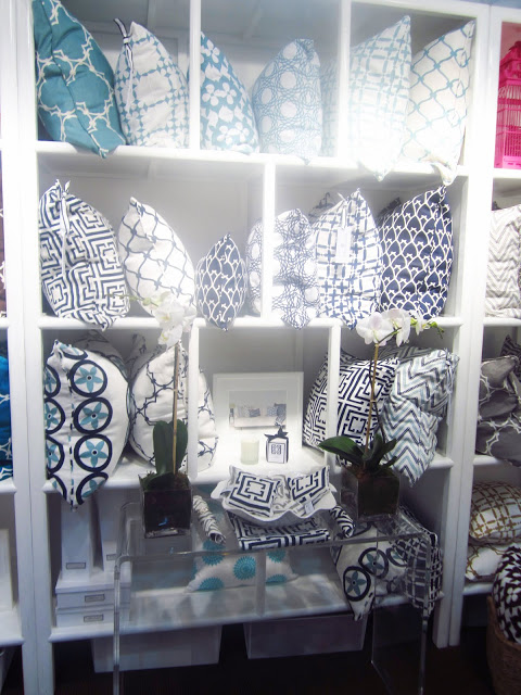 COCOCOZY pillows stacked on a white shelf at the New York International Gift fair