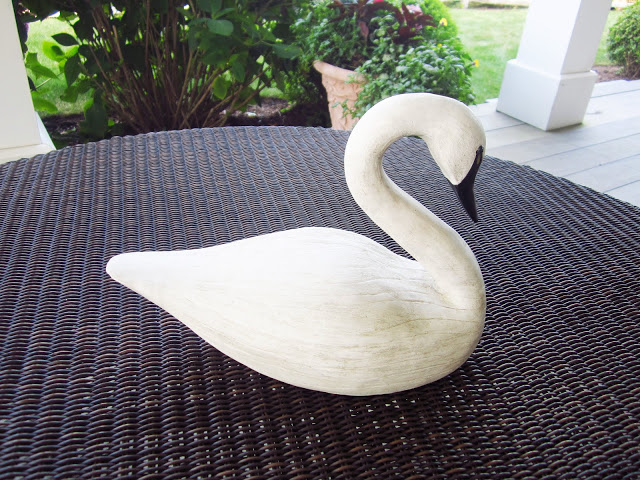 wooden swan on a wicker table