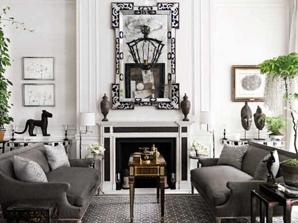 Gray living room with dueling sofas and a black and white fireplace with a large mirror on the matel