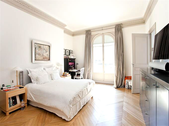 Bedroom in a Paris apartment with herringbone wood floor