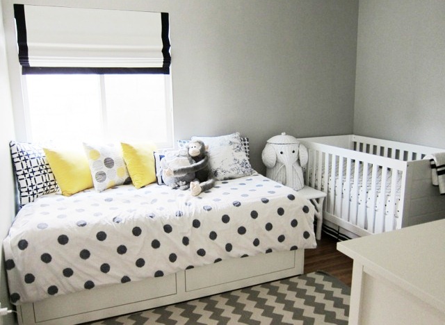 nursery with black and white chevron patterned rug, a twin bed with underbed storage and polka dot bedding, cococozy accent pillows, a white crib and an elephant hamper