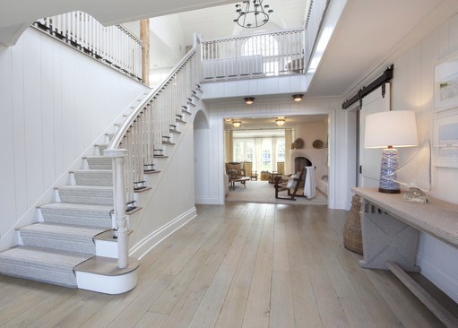 foyer with white wood staircase and oak wood floors