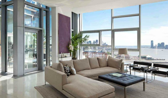 living room with encasement window walls with an amazing view of NYC, gray sectional sofa, black ottoman and modern black chairs