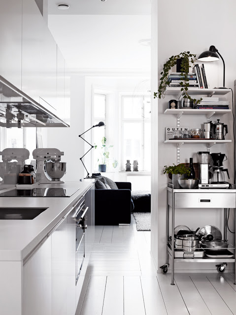 small white kitchen apartment stainless steel cart laminant counters white wood floors