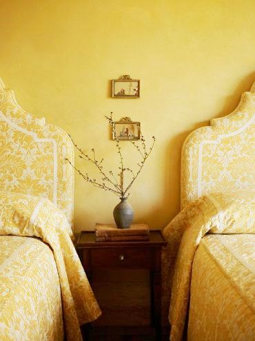Bedroom with two twin beds with tall upholstered yellow brocade headboards