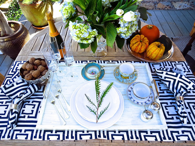 Modern outdoor tea setting with vintage tea cups, a bone and nickle tray, silver flat ware and COCOCOZY napkins and table runner