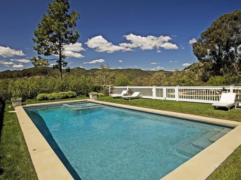 Large pool in the backyard of a Pacific Palisades home with three lounge chairs 