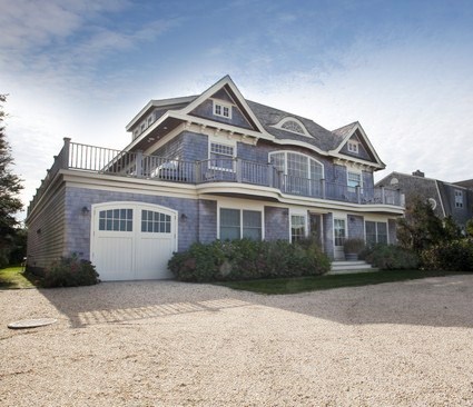 exterior of a house in the Hamptons with a small lawn and driveway made of tiny rocks
