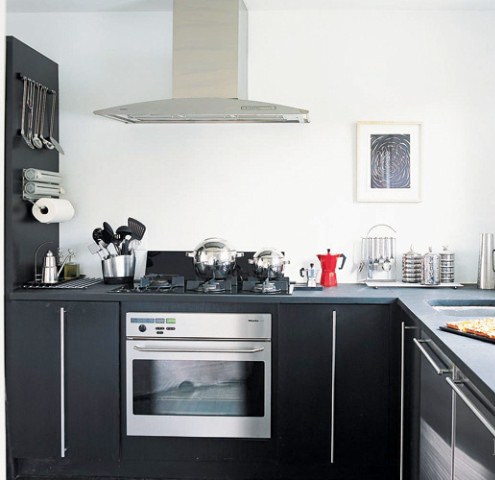 Small kitchen with dark oak cabinets and black poured synthetic cement like counters