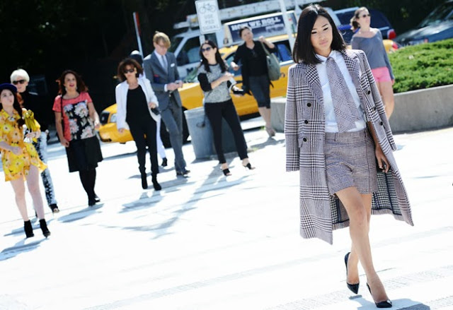 Street style photo of an Asian woman wearing a glen plaid coat and shorts