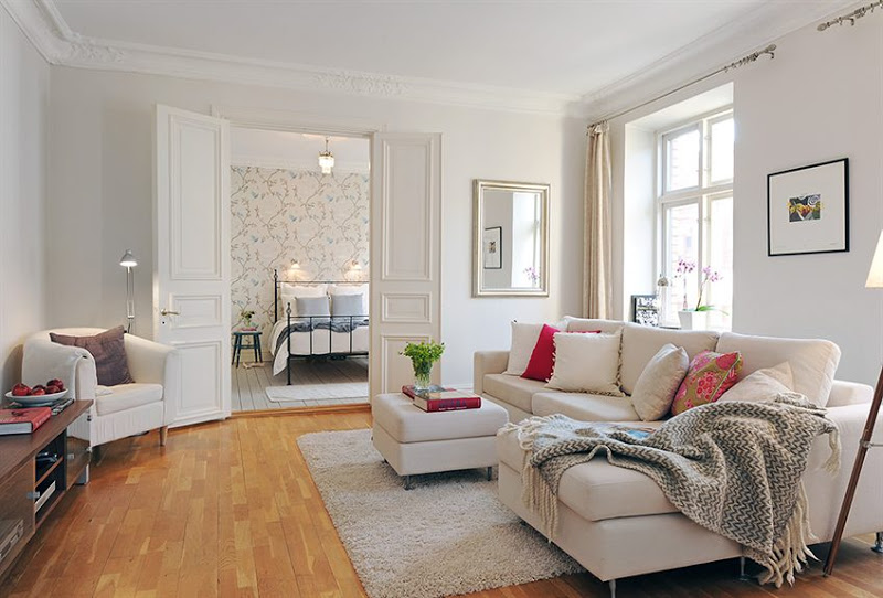 Alternative view of the living room where you can see a taupe armchairs and into the bedroom